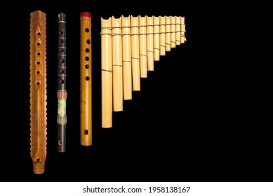 Overhead View Of Four Hand-carved Wooden Flutes In Black Limbo.   The Two On Frame Left Are From India, The Two On The Right Are From Peru.  Space For Graphics Frame Right.