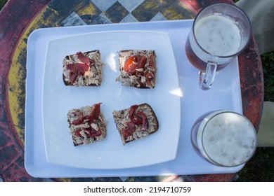 Overhead View Of Four Small Tuna And Red Pepper Sandwiches On Whole Wheat Toast In A Tray On A Metal Table In The Garden. Relax And Eat Outdoors.