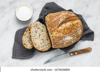 Overhead View Of Fresh Baked Loaf Of Bread Sliced. Rustic Sourdough Bread On A Napkin.