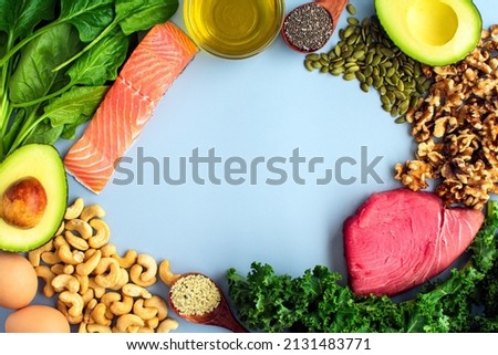 Overhead View of Fresh Omega-3 Rich Foods: A variety of healthy foods like fish, nuts, seeds, fruit, vegetables, and oil rich in omega-3 nutrients