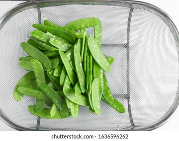 Overhead View Of Fresh Raw Sugar Snap Peas In A Gray Colander