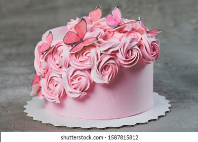 Overhead View Of A Freshly Baked Cake Decorated With Pink Icing Sugar Roses Displayed On A Cake Stand Over A Black Background With Copyspace.