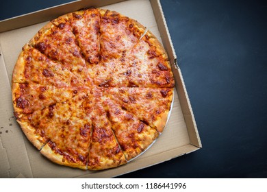 Overhead View Of Freshly Baked Cheeses Pizza In A Pizza Box