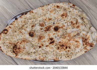 Overhead View Of Garlic Flavored Naan Bread From Indian Restaurant Cooked And Seasoned Perfectly.