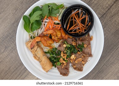 Overhead View Of Generous Bowl Of Vermicelli Salad, Full Of Shrimp, Beef, And Egg Roll For A Vietnamese Meal.