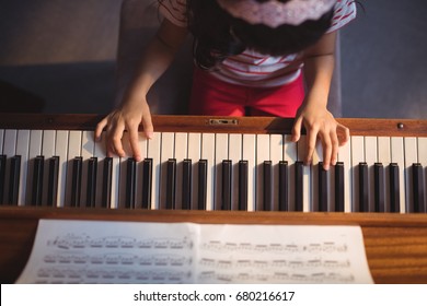 Overhead view of girl practicing piano in classroom at music school - Powered by Shutterstock
