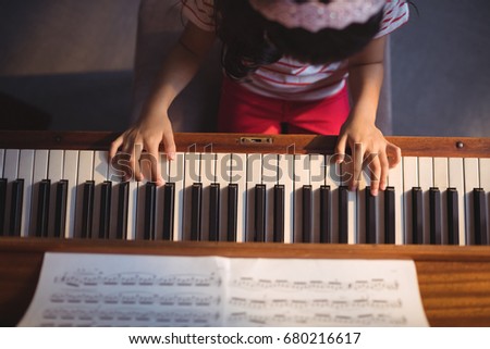 Overhead view of girl practicing piano in classroom at music school