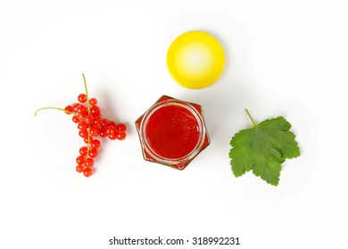 Overhead View Of Glass Jar With Yellow Lid Filled With Fruit Jam, Accompanied By Clusters Of Fresh Red Currant And Green Leaf