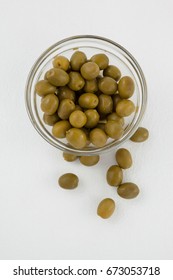 Overhead View Of Green Olives In Glass Bowl On White Table