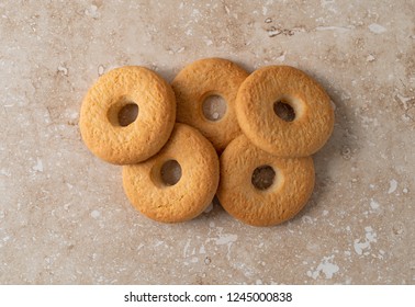 Overhead View Of A Group Of Coconut Cookies On A Beige Marble Counter Top.