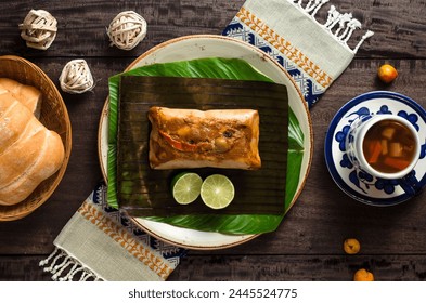 Overhead view of a guate breakfast with tamale, fruit punch and basket of freshly baked bread. - Powered by Shutterstock