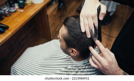 Overhead View Of Hairstylist Cutting Hair Of Man In Blurred Salon