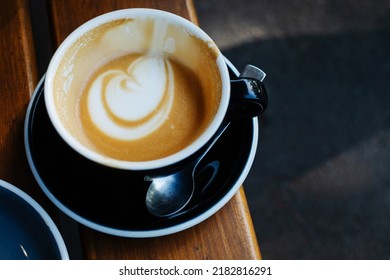 Overhead View Of Half Empty Coffee Latte In Black Mug