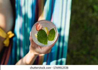 Overhead View Of Hand Holding Glass With Summer Cocktail