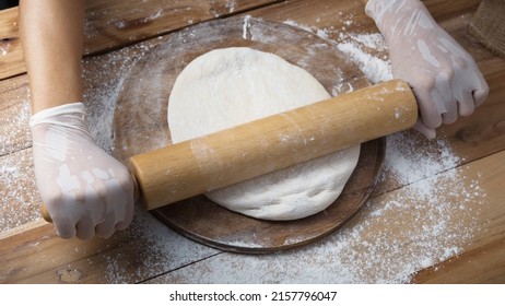  Overhead View Of A Hand Woman Preparing Dough With A Rolling Pin On A Rustic Wooden Table