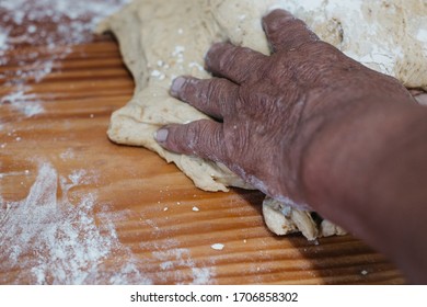 Overhead View Of The Hands Of An Adult Man Kneading Dough In A Wooden