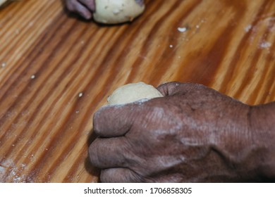 Overhead View Of The Hands Of An Adult Man Kneading Dough In A Wooden