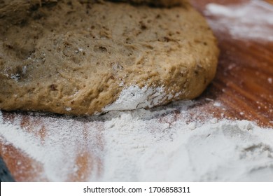 Overhead View Of The Hands Of An Adult Woman Kneading Dough In A Wooden