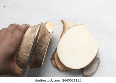 overhead view of hands slicing yam, top view of slicing nigerian white yam, how to cut African yam