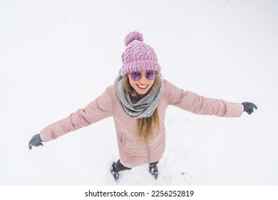 Overhead view of happy woman with hands outstretched to the sides enjoying snowy winter outdoor. High quality photo - Shutterstock ID 2256252819