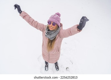 Overhead view of happy woman with raised hands having fun in the snow outdoor. High quality photo - Shutterstock ID 2256252813