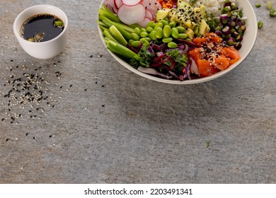 Overhead View Of Hawaiian Poke Bowl With Soy Sauce On Grey Background. Hawaiian Tasty Fresh Food And Healthy Eating.