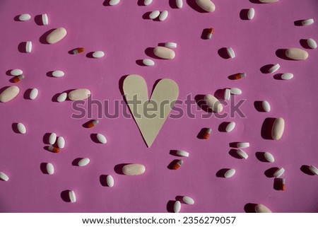 Overhead view of heart surrounded by drugs on a backdrop.