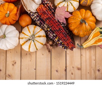 Overhead view of indian corn and mini pumpkins on a rustic wooden background with copy space - Powered by Shutterstock