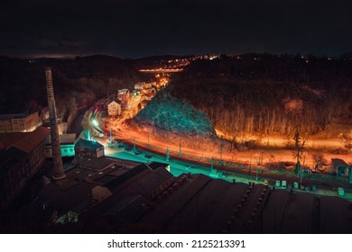 An Overhead View Of An Industrial Site With A Road, A River, And A Railway Track At Night