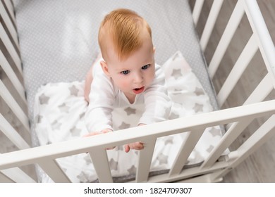 Overhead View Of Infant Boy Standing In Crib