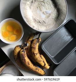 Overhead View Of Ingredients For Homemade Banana Bread, Including Eggs, Bananas, Flour