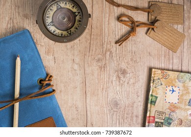 Overhead view of items to plan a trip on a rustic wooden table with copy space. Travel planning concept.
