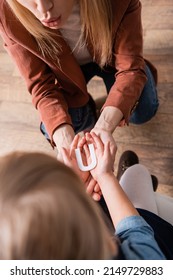 Overhead View Of Kid Holding Letter Near Speech Therapist In Classroom