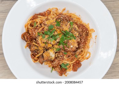 Overhead View Of Large Bowl Of Fettuccini Bolognese Pasta Covered In Sauce, Mushroom, And Garnishment For A Hearty Meal.