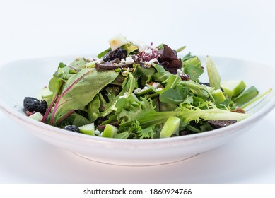 Overhead View Of Large Bowl Of Salad Topped With Prunes And Croutons.