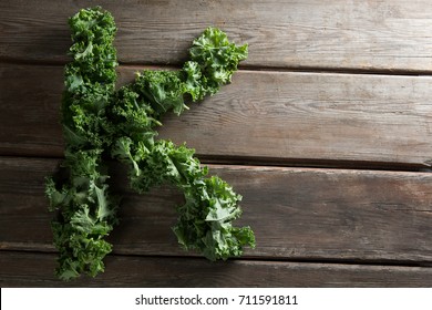 Overhead view of letter K made with kale leaves on wooden table - Powered by Shutterstock