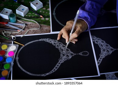 Overhead view, looking down at a jewelry designer sketching a necklace on paper. - Powered by Shutterstock