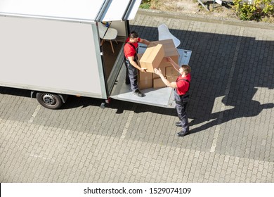 An Overhead View Of A Male Movers Unloading The Cardboard Boxes Form Truck On Street