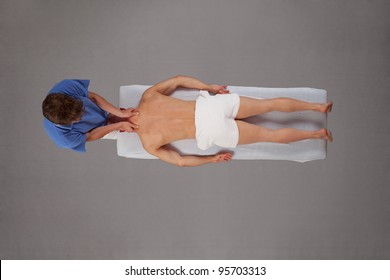 Overhead view of  male therapist  massaging  muscular man neck