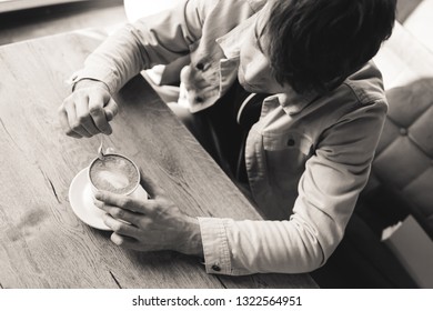 Overhead View Of Man Holding Spoon Near Cup With Cappuccino In Cafe, Black And White Photography