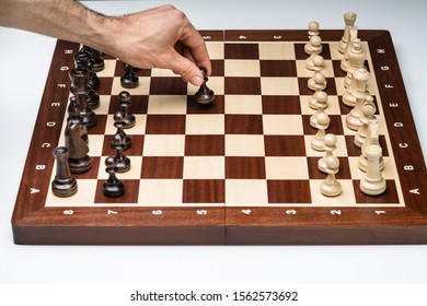 An Overhead View Of Man's Hand Playing The Chess Game Board On White Background