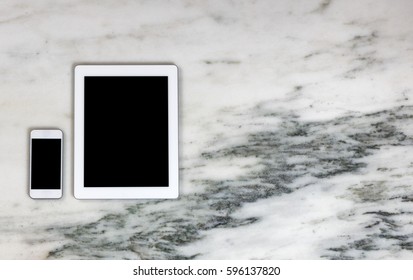 Overhead view of modern wireless mobile communication devices on marble desktop. Paperless office concept.  