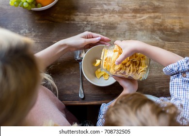 overhead view of mother and son preparing corn flakes for breakfast 