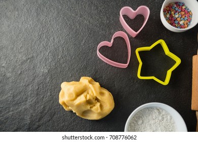 Overhead view of moulds with candies in bowl and dough at table - Powered by Shutterstock