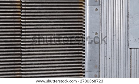Overhead view of moving escalator steps connecting with metal landing plate. Close-up of escalator in subway station or mall. Lines, patterns, durable metal surfaces of public transit infrastructure