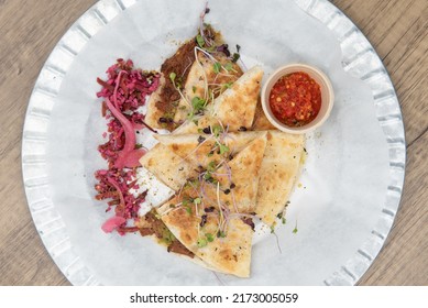 Overhead view of nutritious cheese quesadilla with BBQ jerk jackfruit on a tortilla will start any day with a nutrional boost.