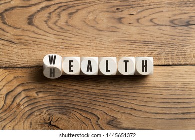 Overhead View On Black Letters Carved On Small Wooden Blocks Spelling Wealth Or Health On Wood Table Surface