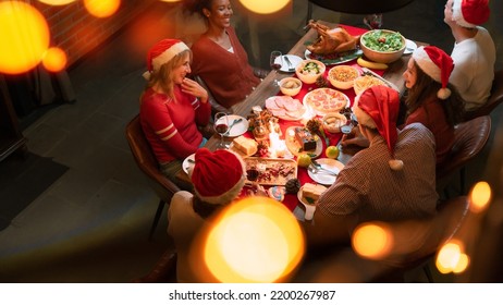 Overhead view on family sitting around christmas table with traditional Christmas roast - Shutterstock ID 2200267987