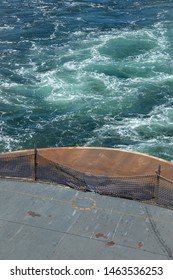 Overhead View On The Stern Deck Of A Ferry Boat, With Turbulent Ocean Waves In The Background