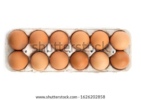 overhead view of one dozen brown eggs in a cardboard egg carton isolated on white